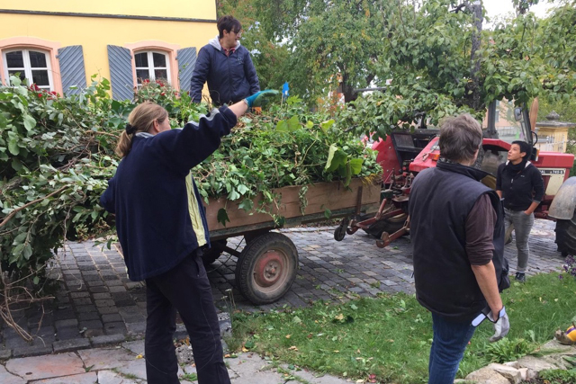 Gruppe von Personen belädt einen Anhänger