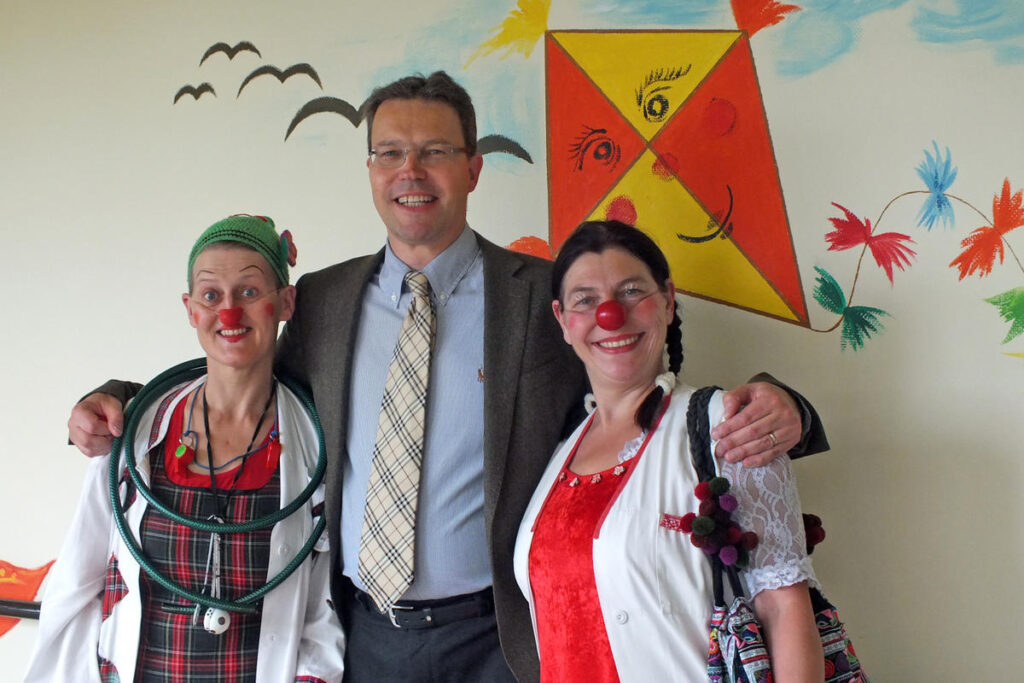 Ein Mann und zwei Clowns im Arztkostüm