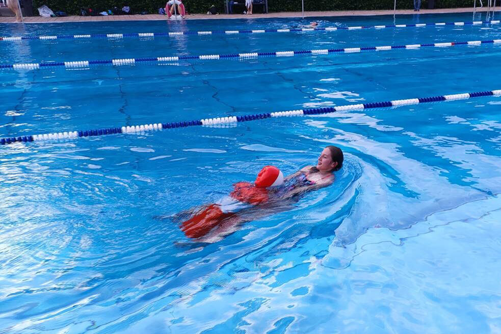 Frau zieht Puppe durch das Wasser