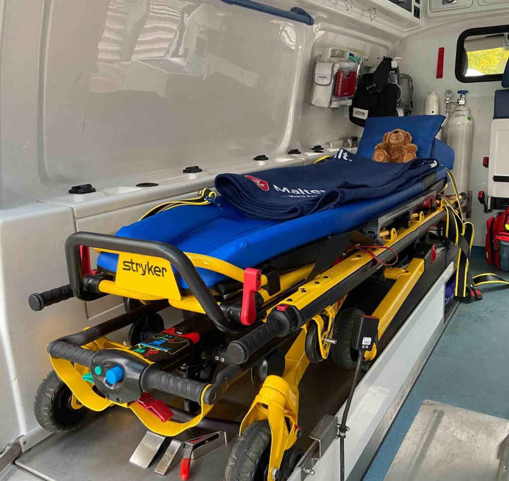 Teddybär liegt auf der Liege im Krankenwagen